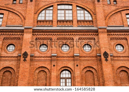 Front of the house of red brick with round windows