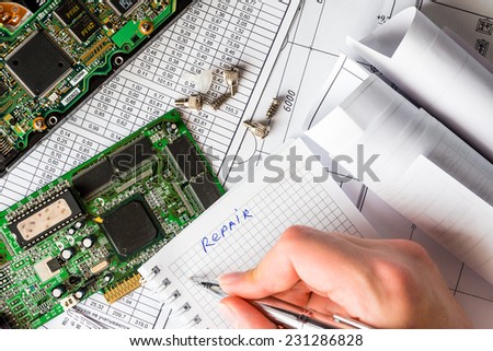 Plan for the repair of the computer, a notebook with a hand holding a pen