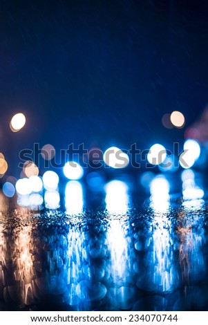 City night headlights, car rides at the rain through the night city
