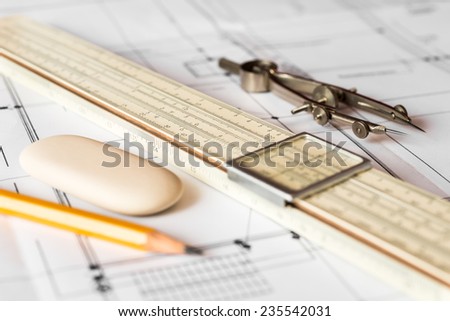 Preparation for drafting papers, the tools and schemes on the table. Angle view, focus on a pencil