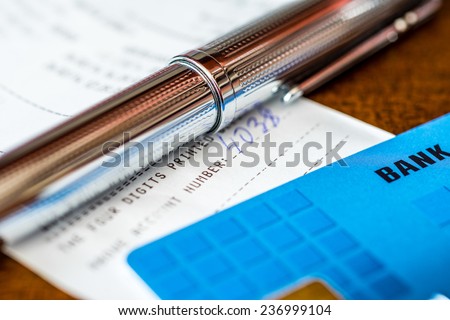 Credit card with a pen and checks on the table