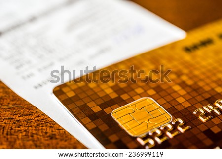 Credit card and check from shopping on the table, focus on the microchip of the card