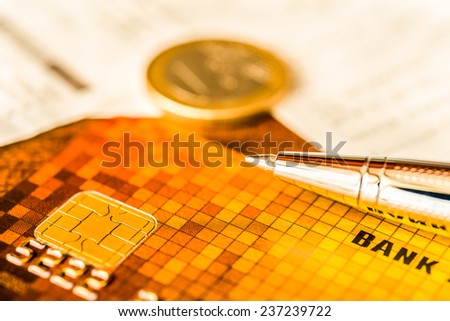 Pay the bills, credit card with pen and money on the table. In yellow tone