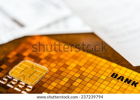 Credit card and check from shopping on the table, focus on the microchip of the card