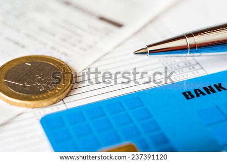 Pay the bills, bank card and pen with check on the table