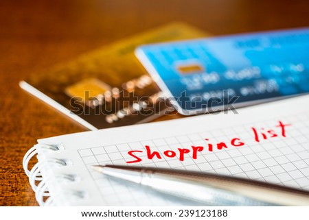 What to buy, list of purchases with a pen and credit cards on the table