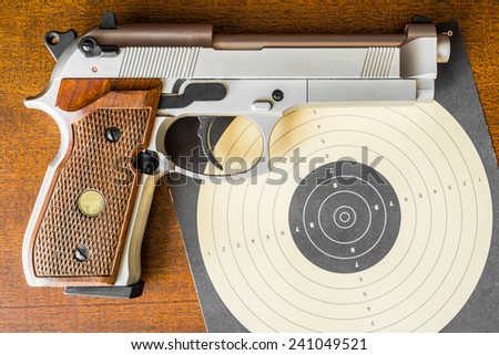 Target shooting, the gun and the target on the table. Top view