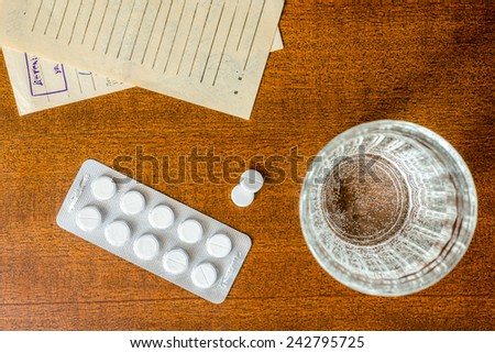 Cure the disease, tablets with a glass of water and prescriptions from the doctor on the table