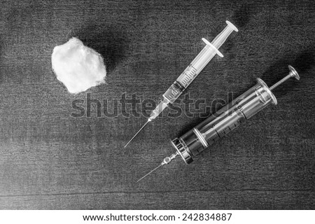 Cure the disease, a two syringe for injection with wadding on the table. Top view, in the black and white tones