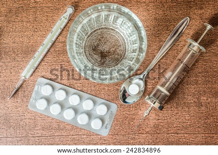 Cure the disease, an injection syringe and take the pills in the spoon. Top view