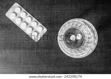 Cure the disease, couple of tablets dissolve in a glass of water. Focus on the glass of water, in the black and white tones