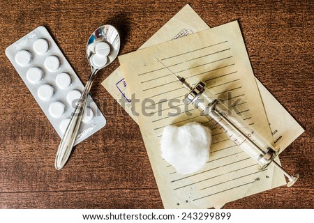 Prescription for the treatment of the disease, a tablets with a syringe on the table. In the old tones