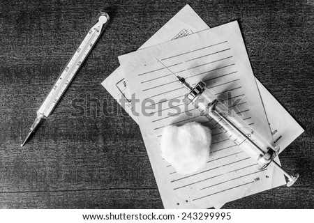 Prescription for the treatment of the disease, syringe injection and prescriptions from the doctor on the table. In the black and white tones