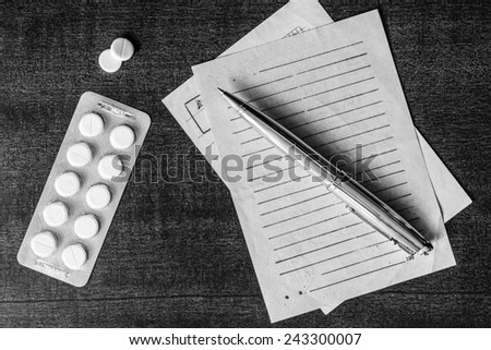 Cure the disease, prescribe the right tablets, recipe and pen on the table. In the black and white tones