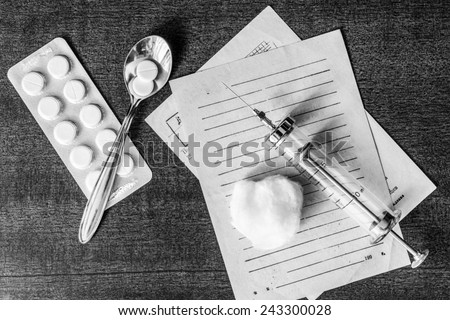 Prescription for the treatment of the disease, a tablets with a syringe on the table. In the black and white tones