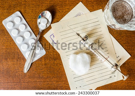 Prescription for the treatment of the disease, a tablets with glass of the water and a syringe on the table