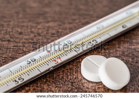 Cure the disease, measure temperature by thermometer and take the pills. Angle view, in old tones