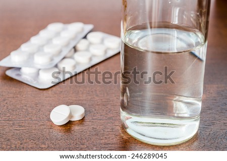 Cure the disease, take the pills on the table and drinking water. Angle view