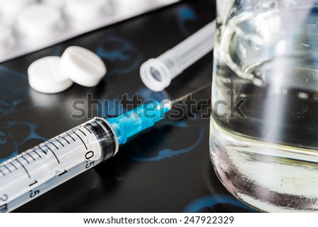 X-ray examination, syringe for injection and glass of the water with a two pills for treatment of disease