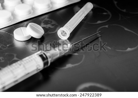 X-ray examination, syringe for injection, a two pills for treatment of disease. In black and white tones