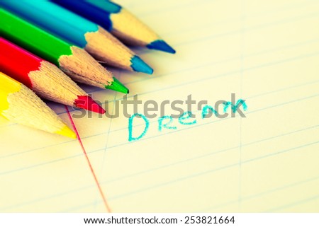 Word dream written in a notebook with colored pencils. Image in warm toning