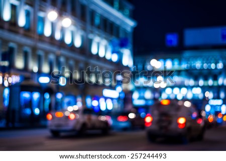 Night city, night life on the streets, the buildings in lights in the background. In blue tones