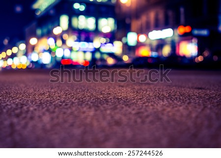 Nights lights of the big city, close up view from asphalt level. Image in yellow-blue toning