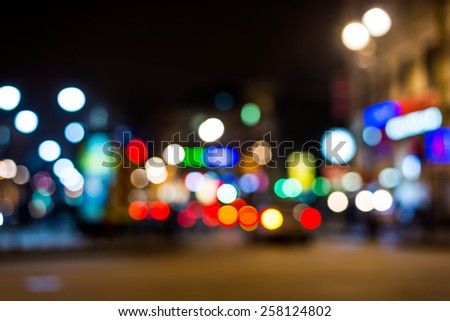 Nights lights of the big city, glowing shop windows and cars on the avenue