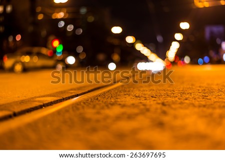 Night highway with rails, cars go over it. View from the level of asphalt