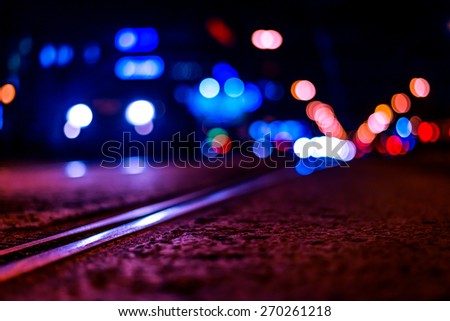 Night highway with rails, car go over it. View from the level of asphalt, image in the purple-blue toning