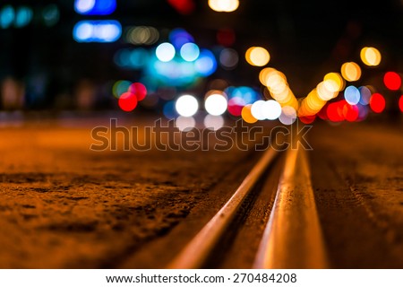 Night highway with rails, cars go over it. View from the level of asphalt