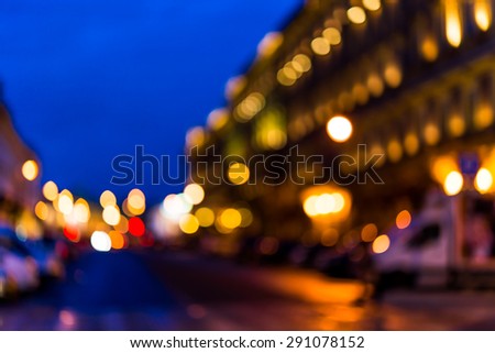 The bright lights of the evening city, empty city street. Defocused image
