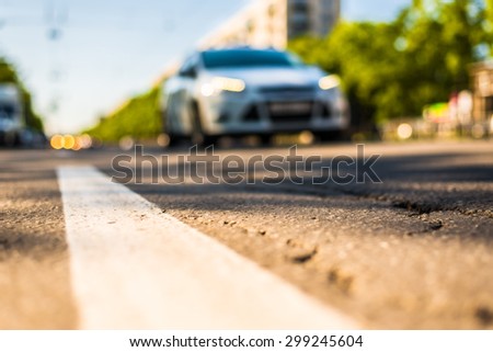 Sunny day in a city, view of the approaching car to the road level