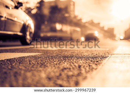 Sunny day in a city, smog on a city street, the view from the level of asphalt. Image in the yellow-purple toning