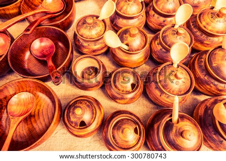 Different wooden utensils on the storefront window. Image in the orange-purple toning