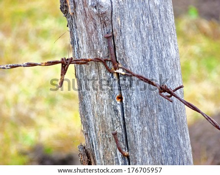 Wooden fence made of wooden sticks and  barbed wire. Various textures