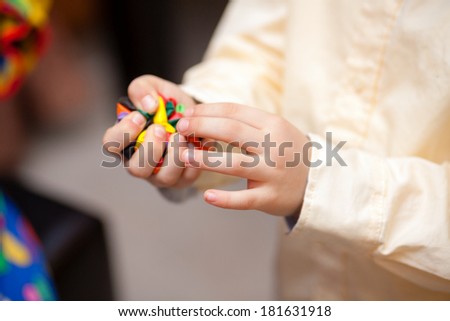 Hands of a child playing with deflated balloons