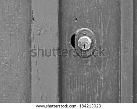 Black and white abstract composition from a wooden painted old door with metallic lock