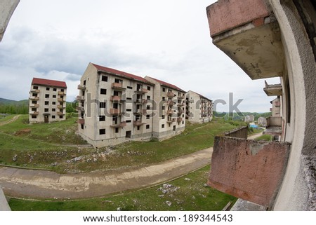 Abandoned blocks of flats under construction. Brick and cement textures with grass around it. Fish eye lens effect