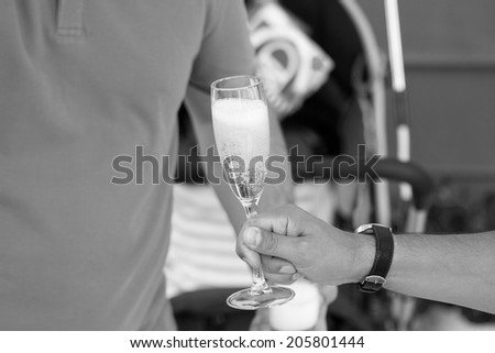 Black and white photo of people holding glasses with champagne at a party