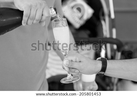 Black and white photo of people holding glasses with champagne at a party