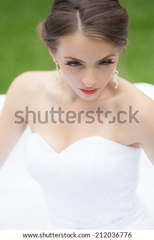 Beautiful, caucasian, blue eyes woman wearing a wedding dress with natural background