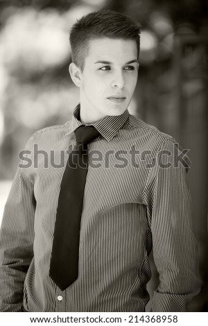 Black and white photo of a handsome young man wearing a shirt and tie. Street shooting in Timisoara, Romania