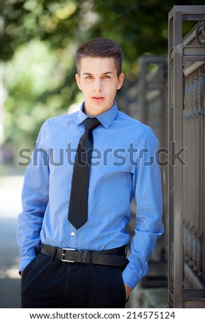 Handsome, brown eyed, young man wearing a blue shirt and tie. Street shooting in Timisoara, Romania