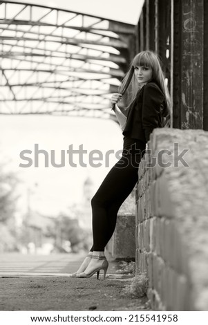 Black and white photo of a beautiful, caucasian, young, long haired woman posing in urban locations