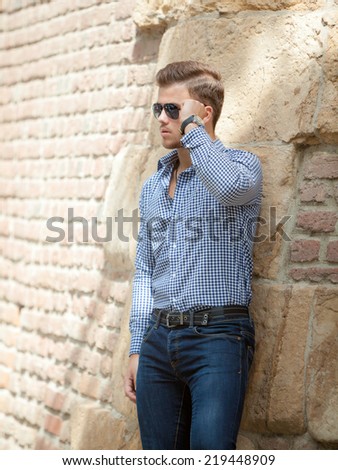Handsome young man wearing a blue shirt and jeans. Street shooting in Timisoara, Romania