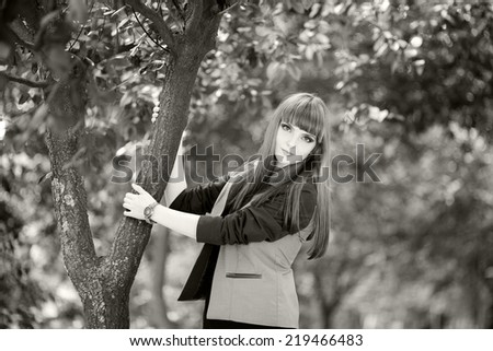 Black and white photo of a beautiful, caucasian, young, long haired, brown eyed woman posing in urban locations with natural background