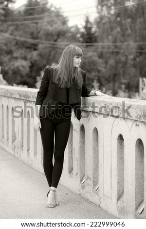 Black and white photo of a beautiful, caucasian, young, long haired woman posing in urban locations