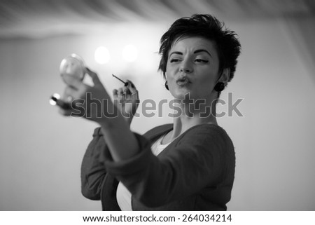 Photo session of an expressive,short haired, brunette woman during the make up session. Black and white photography