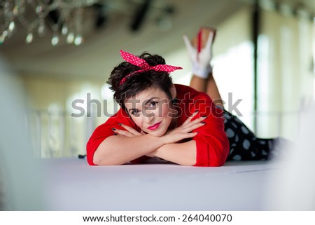 Photo session of an expressive,short haired, brunette woman sitting on the floor
